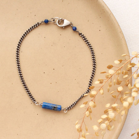 The sydney lapis bracelet styled on a tan plate with dried grass