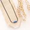 The sydney lapis necklace styled on tan linen with dried grass