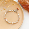 The desert bracelet styled on a tan plate with dried grass and a red crystal