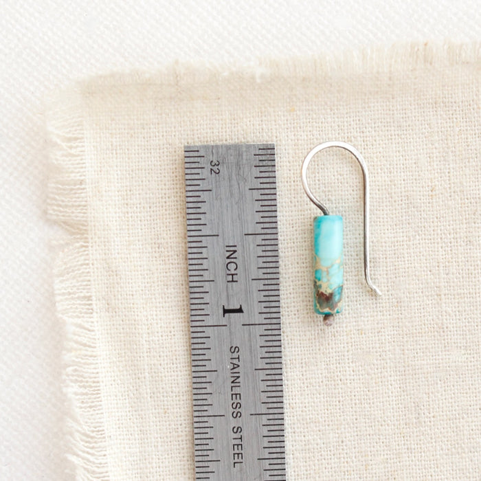 A sydney sea sediment jasper earring next to a ruler for size reference