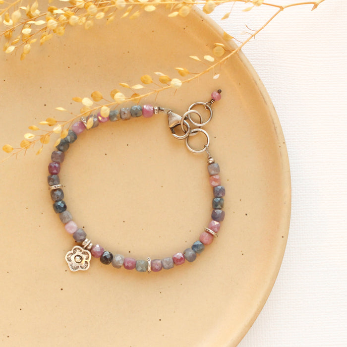 The mini cactus flower sapphire bracelet styled on a tan plate with dried grass