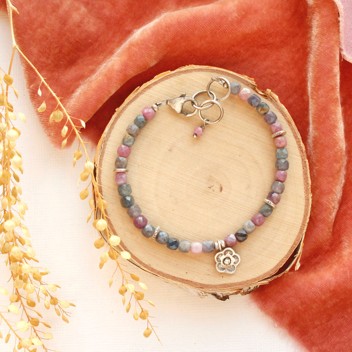 The mini cactus flower sapphire bracelet styled on wood with pink velvet and dried grass