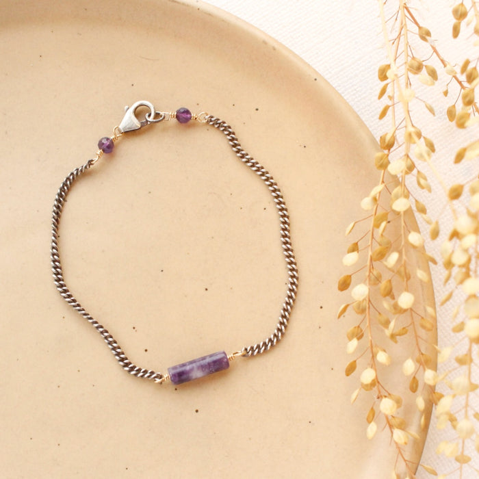The sydney lepidolite bracelet styled on a tan plate with dried grass