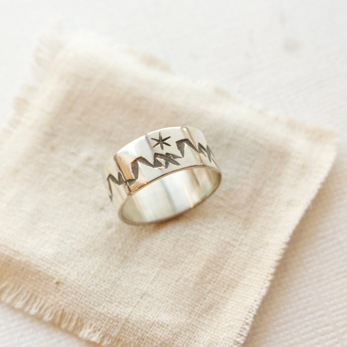 The stamped mountain range ring styled on tan linen