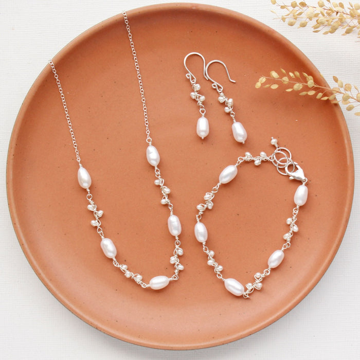 The bright silver wrapped pearl bud vine set styled on an orange plate with dried grass