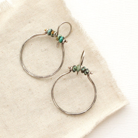 The african jasper halo hoop earrings styled on tan linen