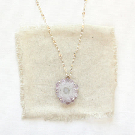 The amethyst stalactite flower necklace styled on tan linen