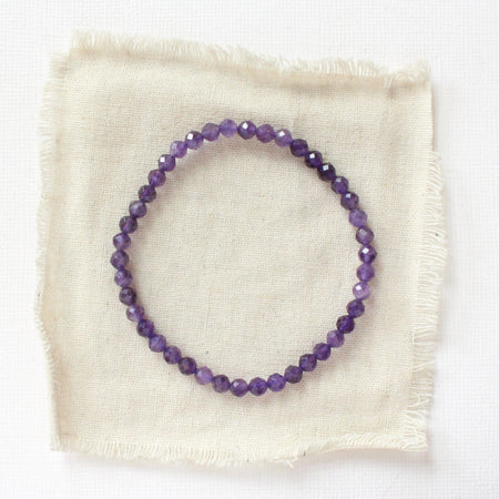 The amethyst stretch bracelet styled on tan linen
