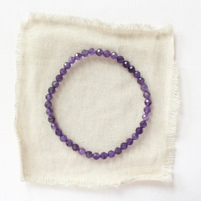 The amethyst stretch bracelet styled on tan linen