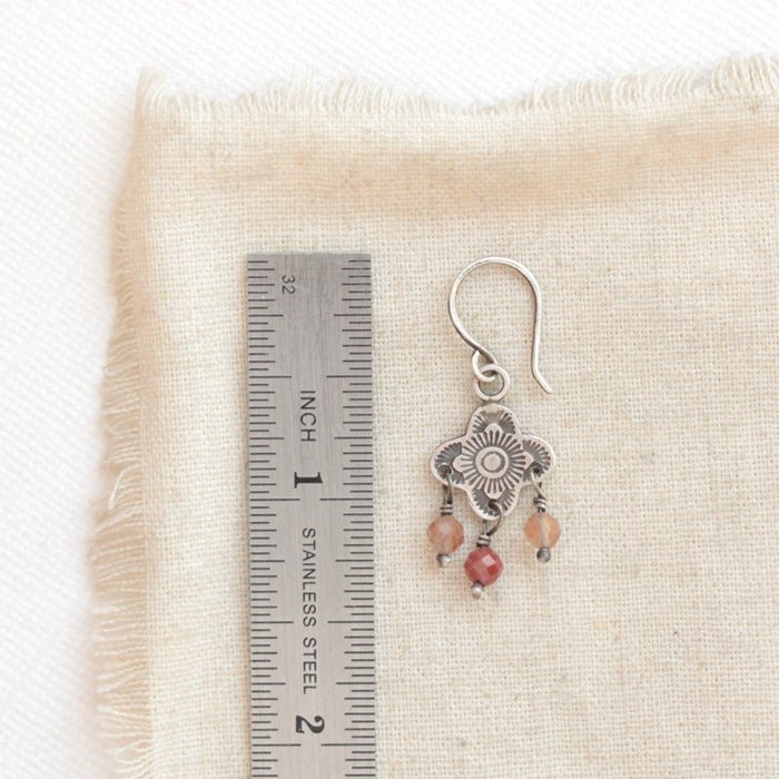 A mini talara andesine earring next to a ruler for size reference