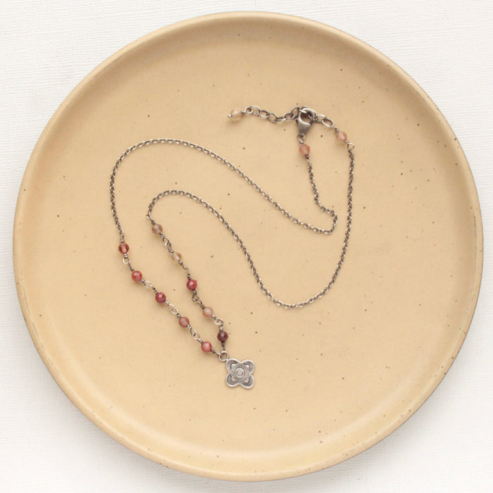 The andesine mini talara necklace styled on a tan plate to show the adjustable lobster clasp closure