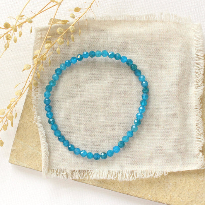 The apatite stretch bracelet bracelet styled on a tan rock with linen and dried grass