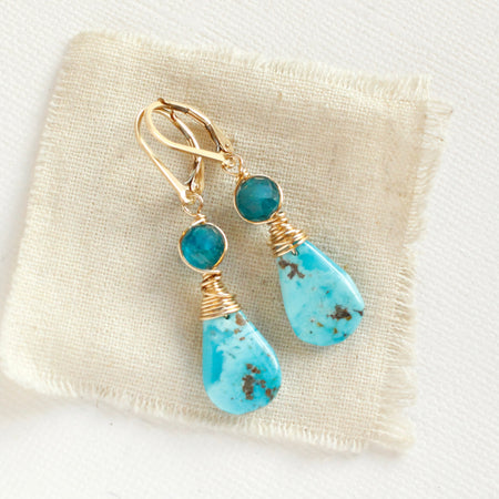 The apatite and turquoise drop earrings styled on tan linen
