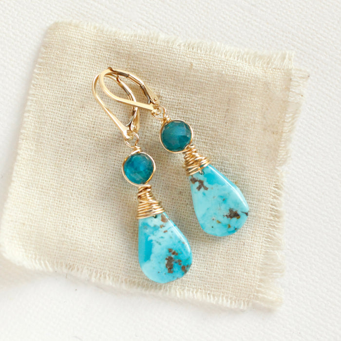 The apatite and turquoise drop earrings styled on tan linen