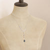 A mannequin wearing the aquamarine drop lariat necklace