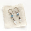 The aquamarine and moonstone earrings styled on tan linen