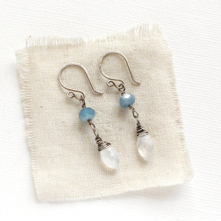 The aquamarine and moonstone earrings styled on tan linen