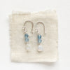The aquamarine and moonstone earrings styled on tan linen
