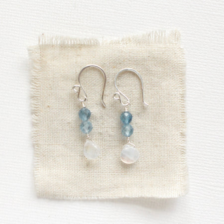 The aquamarine and moonstone earrings styled on tan linen