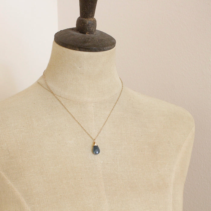 A mannequin wearing the aquamarine drop gold necklace