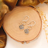 The aspen leaf hoop earrings styled on wood with yellow velvet and dried grass