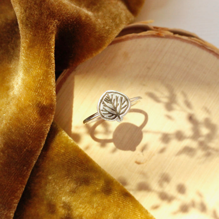 The aspen leaf ring styled on wood with yellow velvet