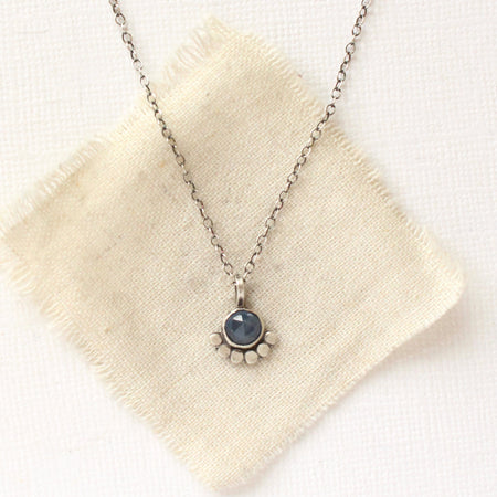 The beaded sapphire necklace styled on tan linen