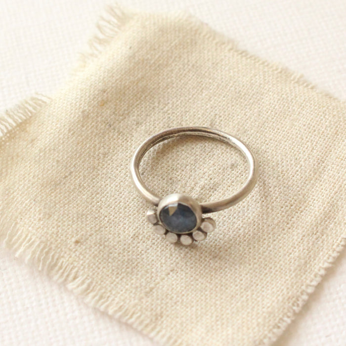 The simple silver band of the beaded sapphire ring