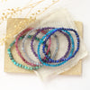 Beaded stretch bracelets styled on a tan rock with linen and dried grass
