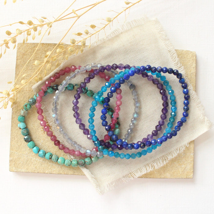 Beaded stretch bracelets styled on a tan rock with linen and dried grass