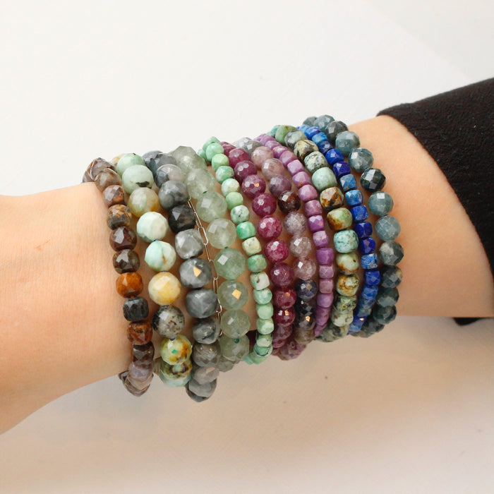 A bunch of beaded stretch bracelet being worn on a wrist