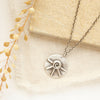 The big musana necklace styled on linen with a tan rock and dried grass