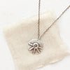 The big musana necklace styled on tan linen