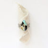 The black jack turquoise band ring styled on rolled tan linen