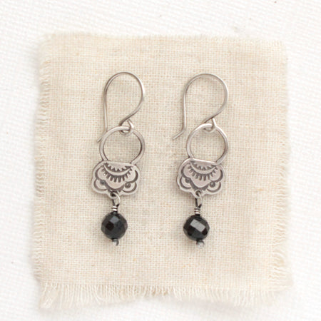 The black tourmaline jolie earrings styled on tan linen