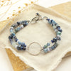 The blue double strand bracelet styled on a tan rock with linen and dried grass