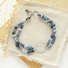 The blue double strand bracelet styled on a tan rock with linen and dried grass