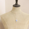 A mannequin wearing the blue flower and pearl drop vintage plate necklace