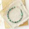 The country roads gemstone bracelet styled on a tan rock with linen and dried grass