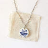 The blue sprig vintage plate necklace styled on tan linen