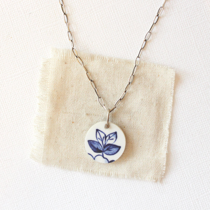 The blue sprig vintage plate necklace styled on tan linen