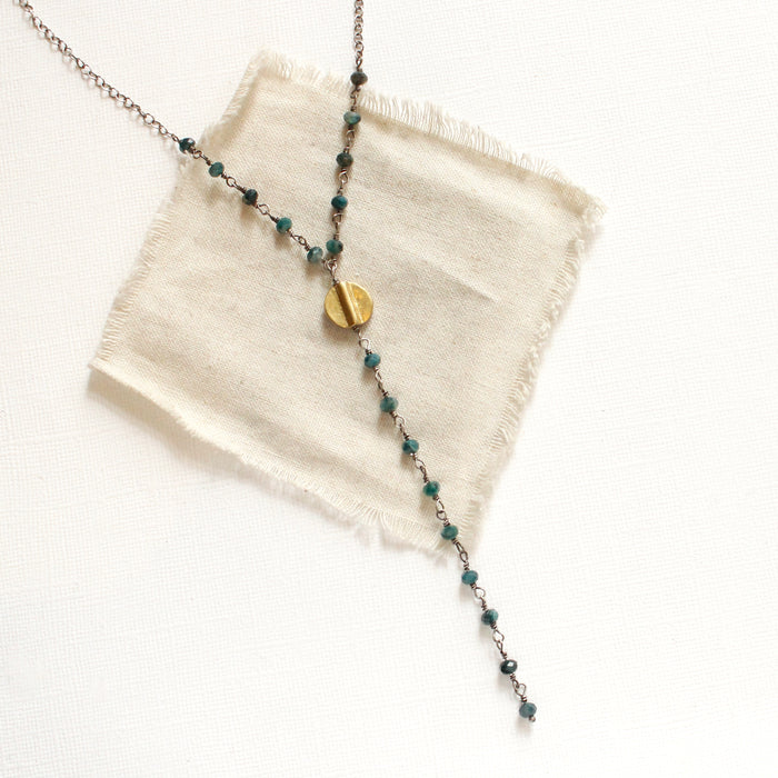 The grandidierte mythos lariat necklace styled on tan linen