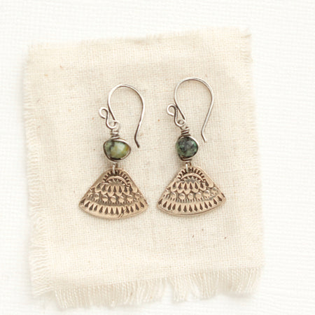 The bronze asmi triangle and african jasper earrings styled on tan linen
