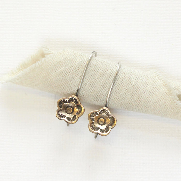 The bronze mini cactus flower lobe hugger earrings styled on rolled linen