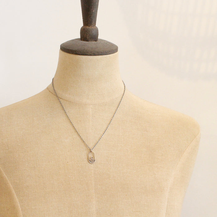 A mannequin wearing the bronze wanderer hoop necklace