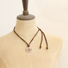 A mannequin wearing the bronze wanderer medallion leather necklace in the short style