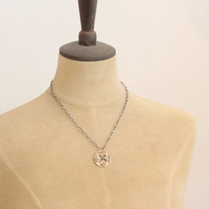 A mannequin wearing the bronze wanderer medallion necklace