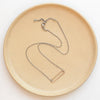 The bronze open bar necklace styled on a tan plate to show the adjustable lobster clasp closure