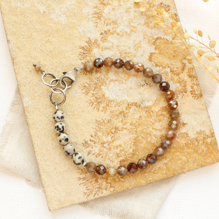 The cairo bracelet styled on a tan rock with linen and dried grass