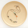 The talara sun mesa necklace styled on a tan plate to show the adjustable lobster clasp closure